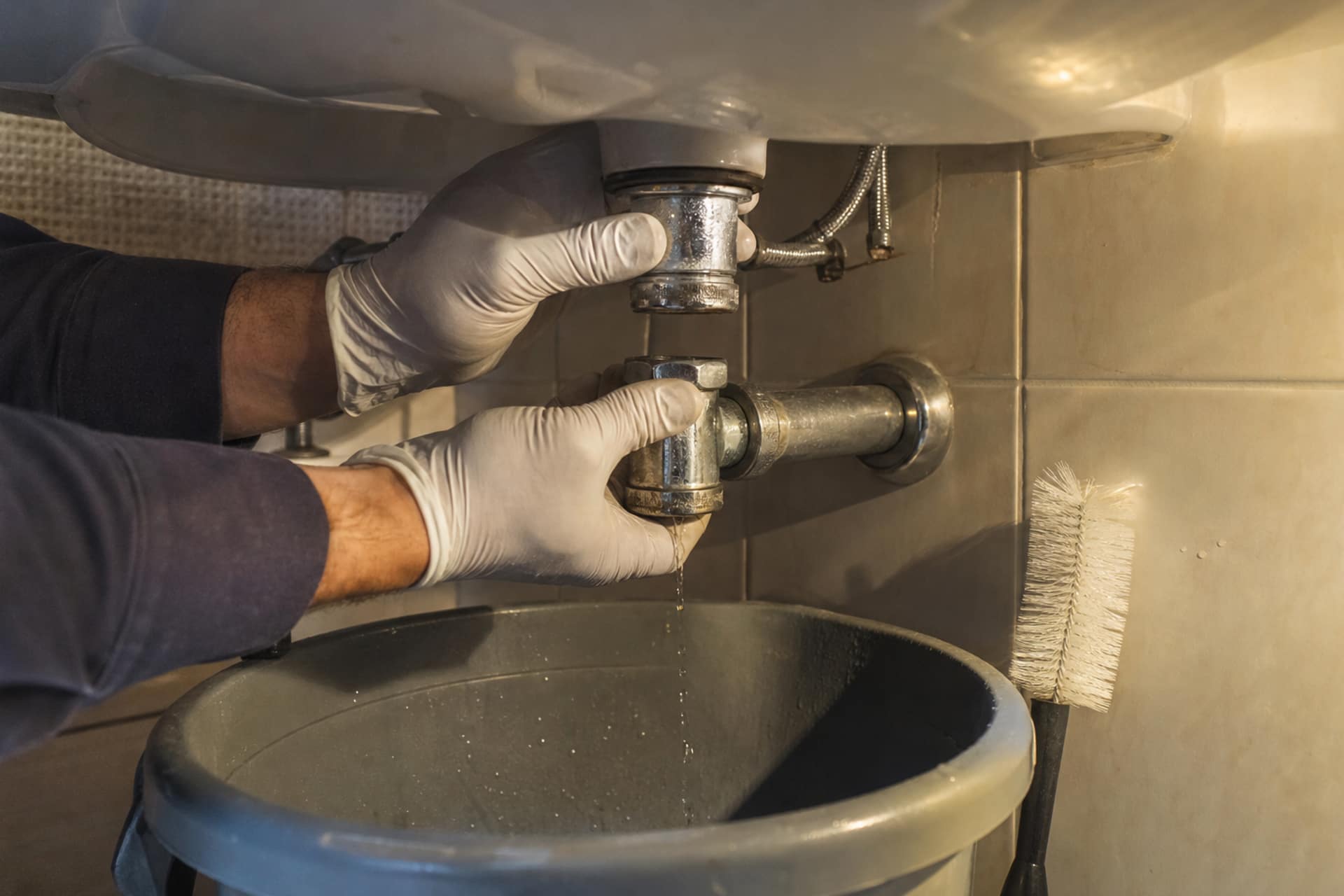 gouttes au raccord de lavabo, mains intervenant